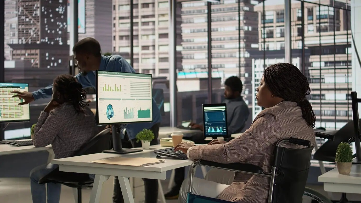 Schwarze Führungskraft im Rollstuhl überprüft die Finanzdaten für Monatsberichte.